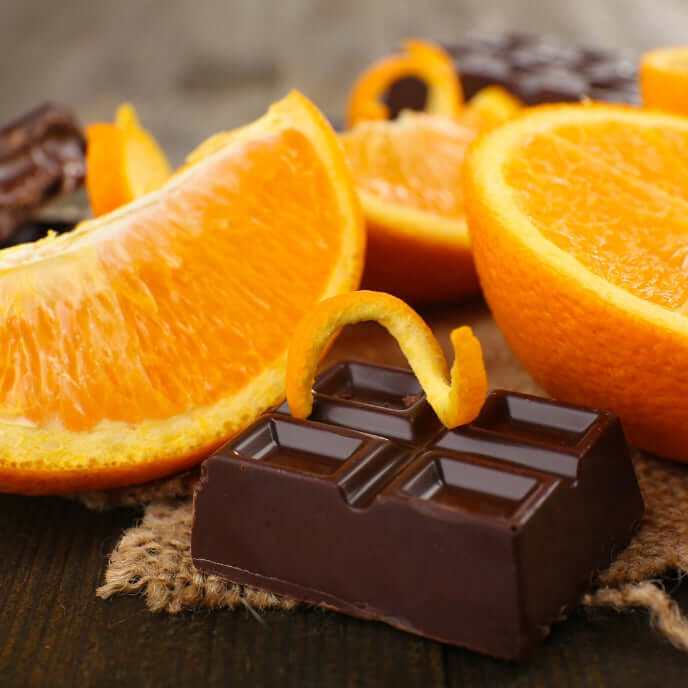 Fette di Arancia e tavoletta di Cioccolato per indicare una omonima fragranza per candele profumate. Materia prima con arancia, mandorla, cioccolato fondente e vaniglia come Note Olfattive.