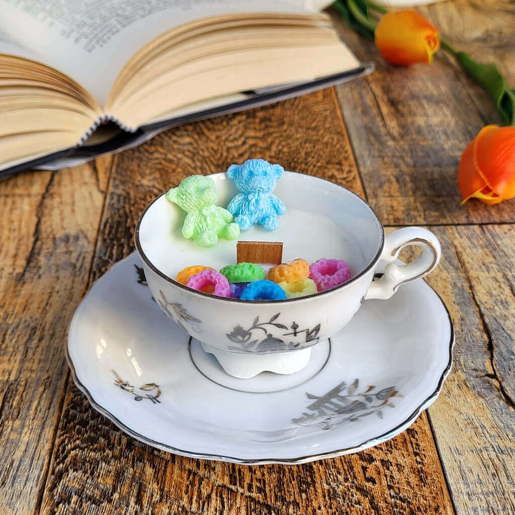 Candela profumata in cera di soia realizzata all'interno di una elegante Tazzina da Caffè in Porcellana Bavaria. Decorazioni di cereali colorati e orsetti, fatti di cera.
