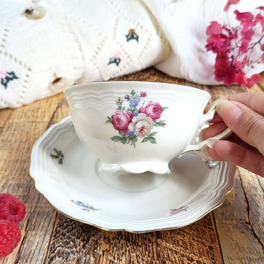 Candela profumata Macaron Lampone e Violetta, realizzata in cera di soia vegetale all'interno di una elegante Tazza da Tea in Porcellana Bavaria. Dettaglio decorazione a fiori.