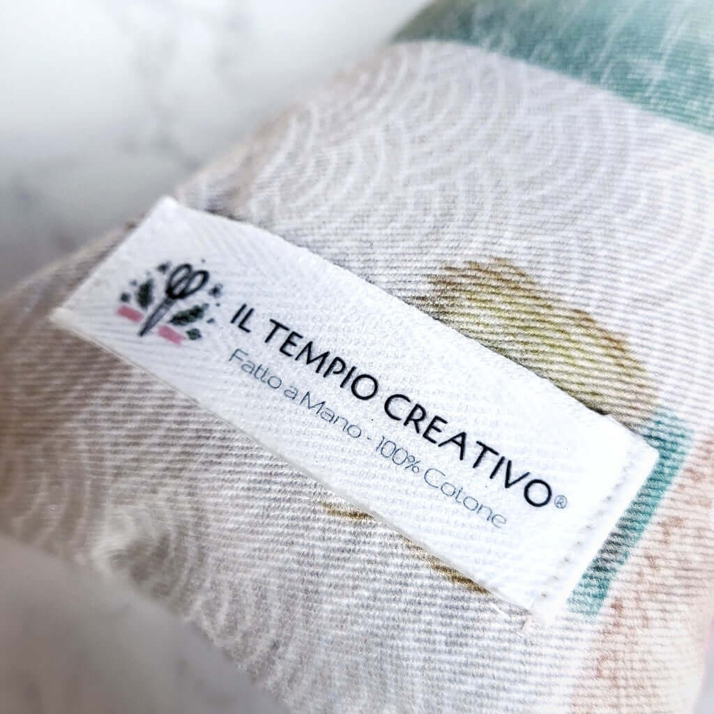 Dettaglio etichetta. Cuscino Benessere in cotone e noccioli di ciliegia Riscaldante/Termico per Cervicale.