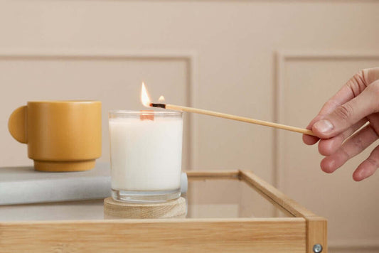 Accensione di una candela profumata con un lungo fiammifero 
