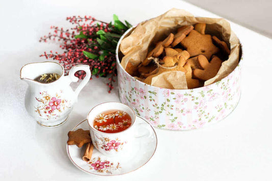Tazza vintage e lattiera di porcellana con biscottiera piena di biscotti