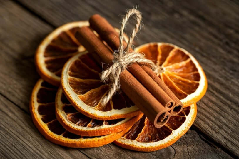 Fette di Arancia Essiccata e Stecche di Cannella per decorare Candele Profumate a Tema Natale.
