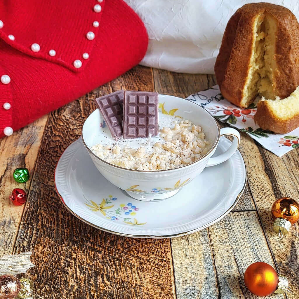 Candela profumata in cera di soia realizzata all'interno di una elegante Tazza da Tea in Ceramica Bavaria. Sullo sfondo un piccolo pandoro per richiamare la profumazione.
