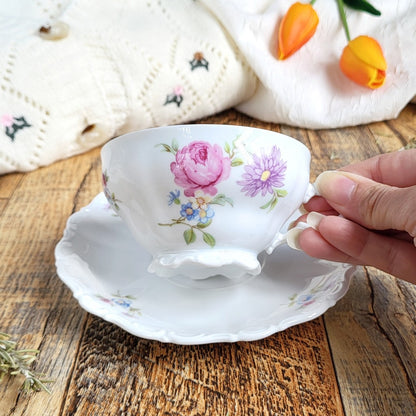 Candela profumata Albicocca e Rosmarino, realizzata in cera di soia vegetale all'interno di una elegante Tazza da Tea in Porcellana Bavaria. Dettaglio decorazione di fiori colorati.