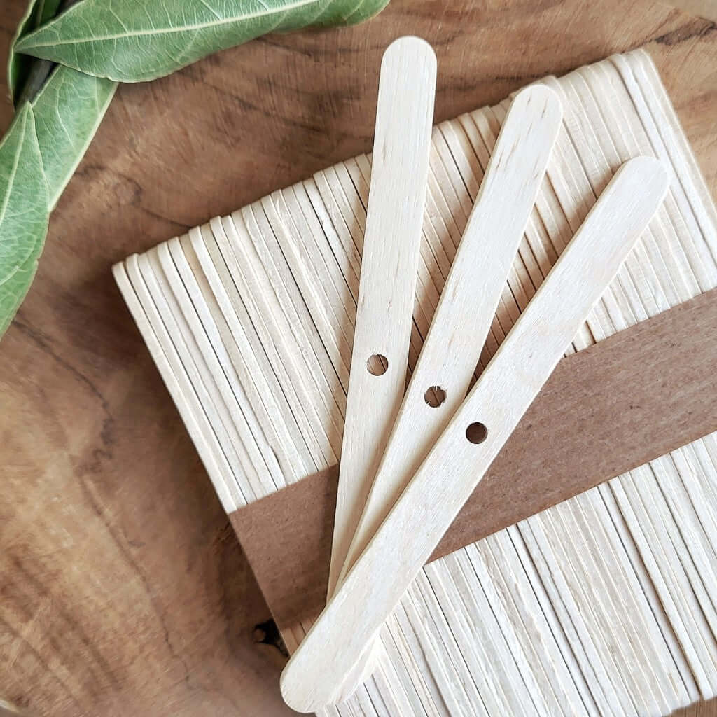 Ferma stoppino in legno naturale di betulla per candele artigianali. Presenta un foro per centrare lo stoppino in cotone e bobine a metraggio nelle candele fatte a mano. Pack da 50