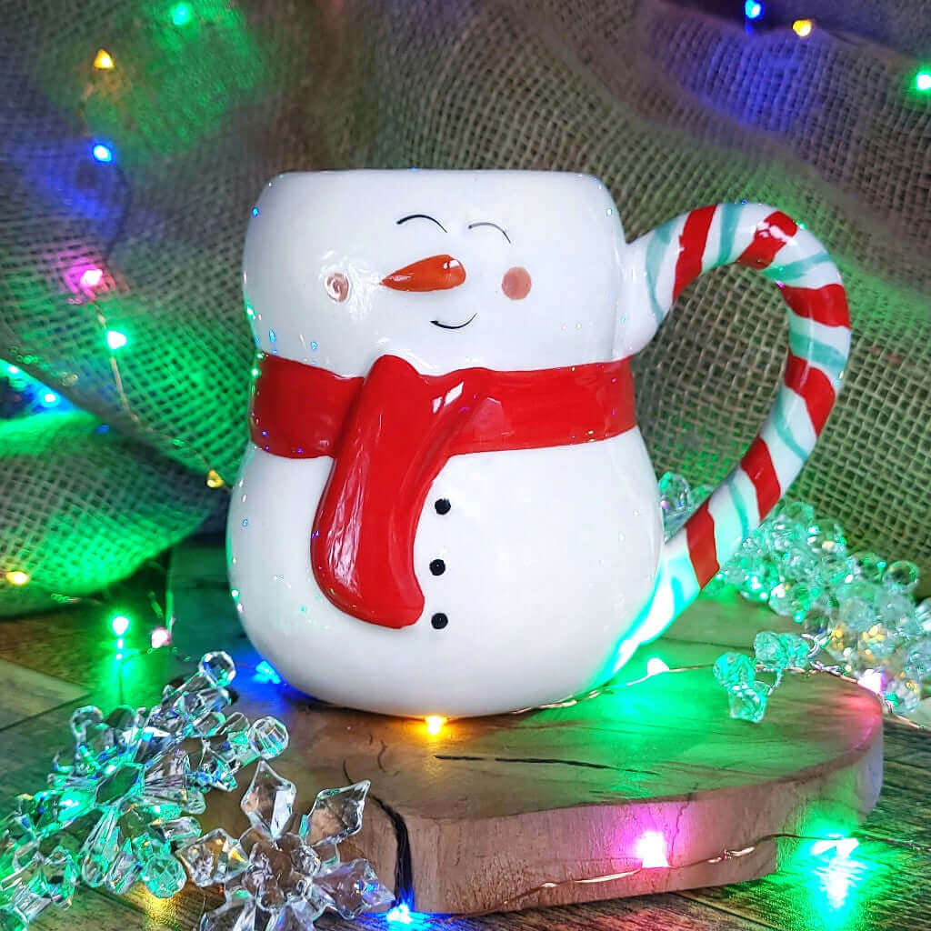 Tazza in ceramica a forma di pupazzo di neve, più luci di Natale colorate.