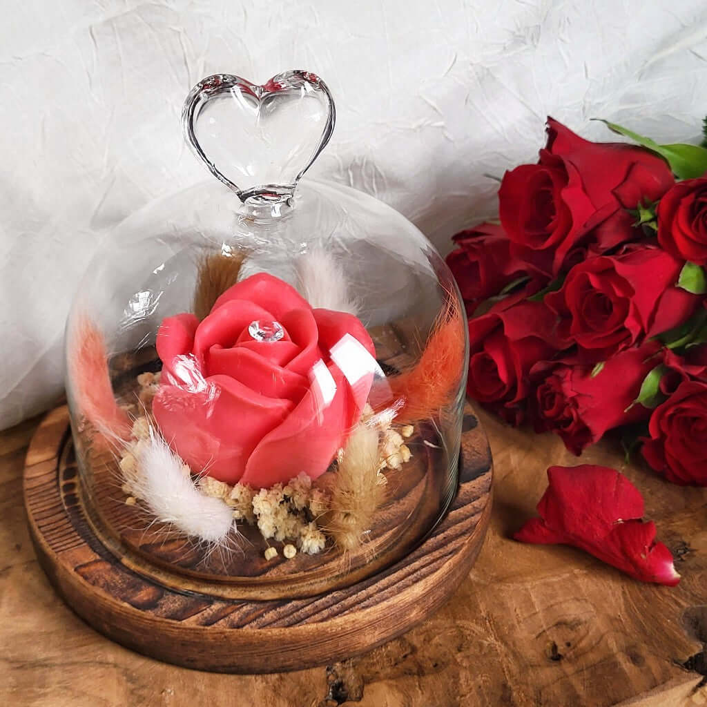 Candela profumata in cera di soia a forma di rosa con al centro un diamante. È realizzata in stile bouquet, con decorazioni pampas e fiori da sposa, all'interno di una campana in vetro trasparente con cuore e base in legno. Idea Regalo Festa della Mamma.