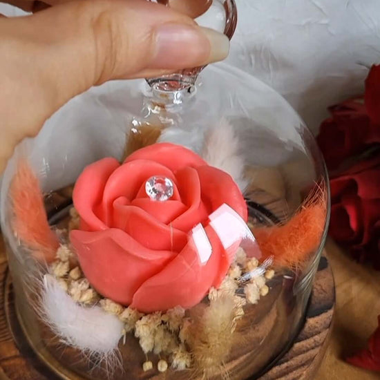 Candela profumata in cera di soia a forma di rosa con al centro un diamante. È realizzata in stile bouquet, con decorazioni pampas e fiori da sposa, all'interno di una campana in vetro trasparente con cuore e base in legno. Idea Regalo Festa della Mamma 