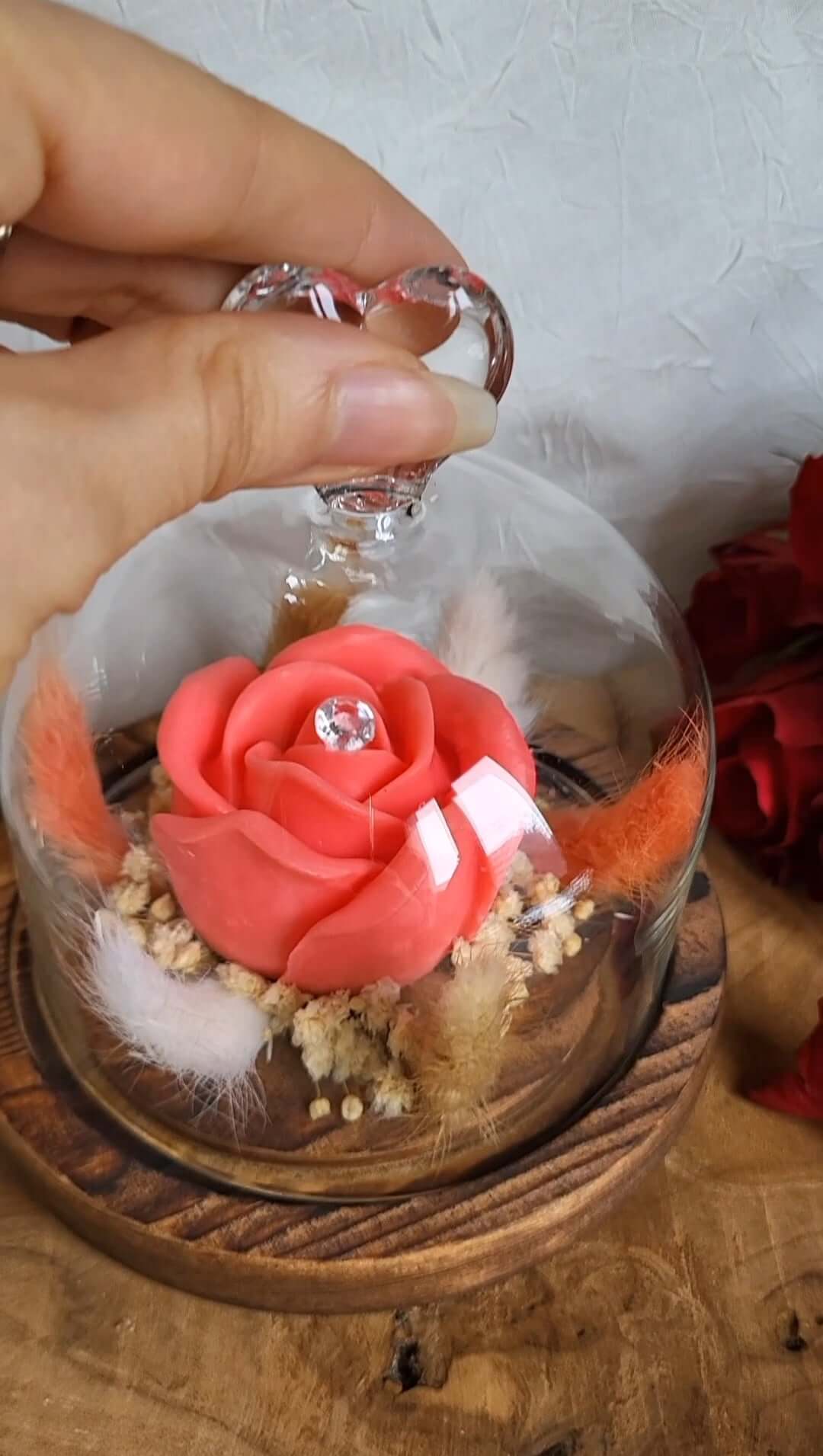 Candela profumata in cera di soia a forma di rosa con al centro un diamante. È realizzata in stile bouquet, con decorazioni pampas e fiori da sposa, all'interno di una campana in vetro trasparente con cuore e base in legno. Idea Regalo Festa della Mamma 