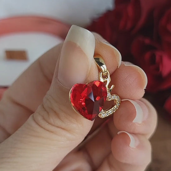 Ciondolo Bijoux dorato con doppio cuore, uno rosso ed uno con finti zirconi luminosi, più piccola corona.