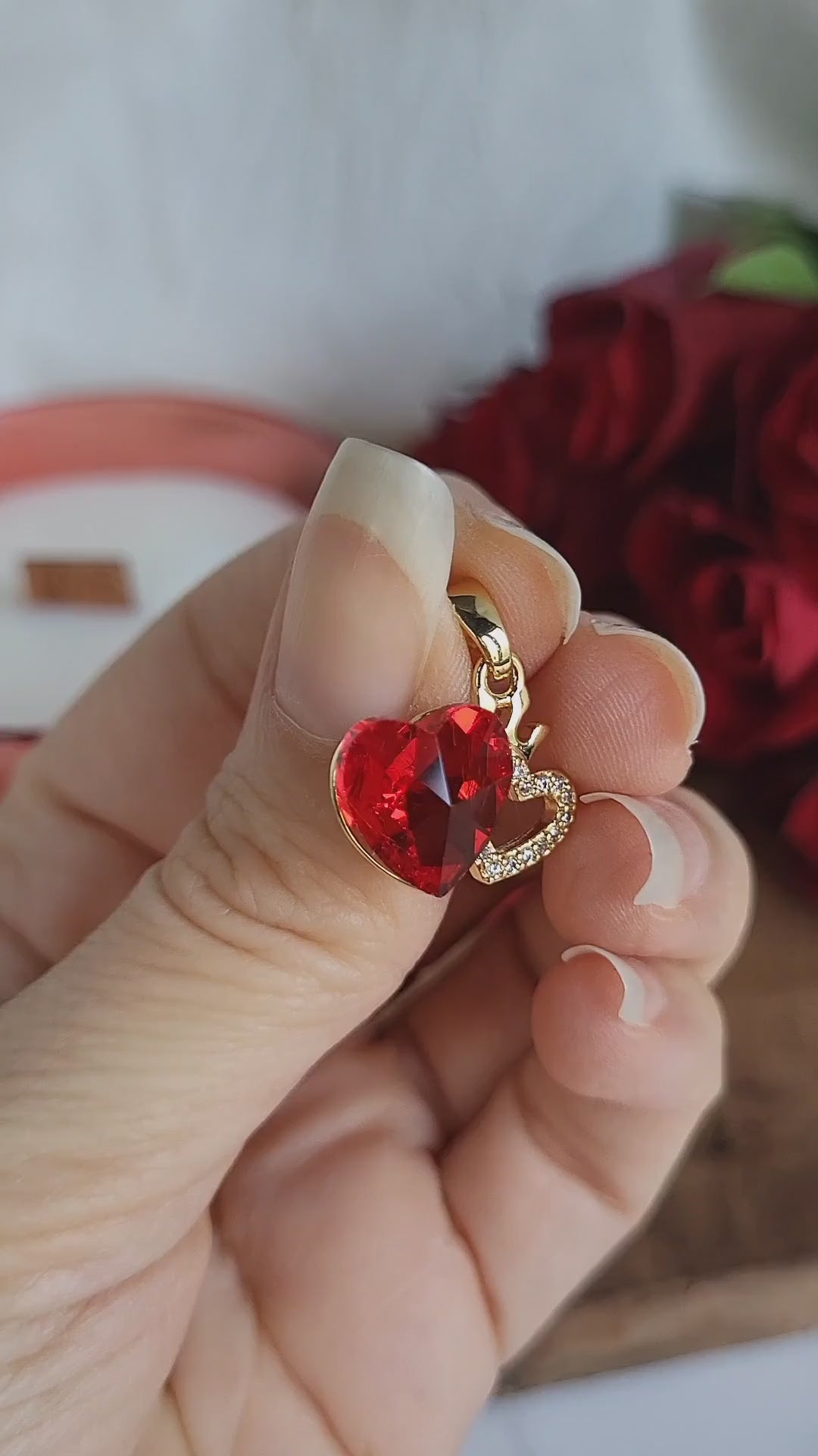 Ciondolo Bijoux dorato con doppio cuore, uno rosso ed uno con finti zirconi luminosi, più piccola corona.