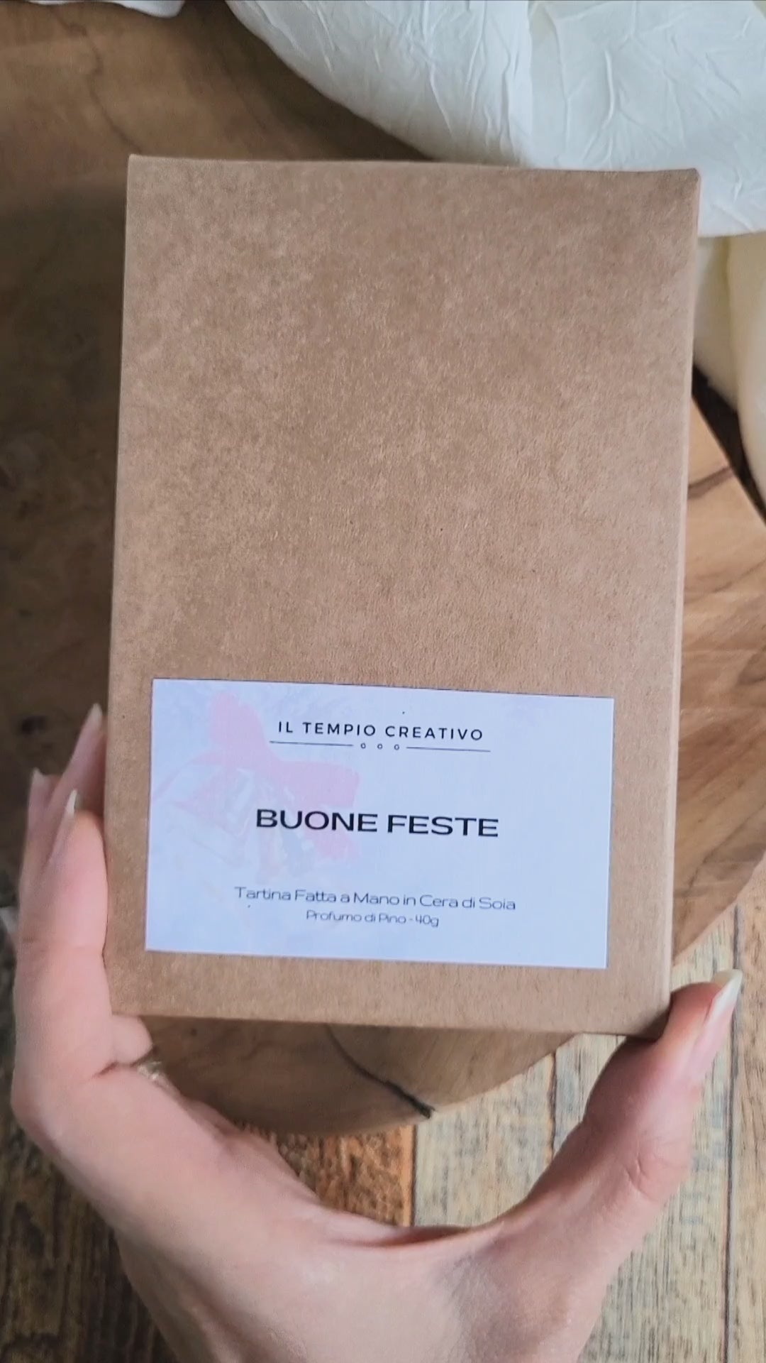 Tartina Profuma Armadi e Cassetti in cera di soia naturale al profumo di Pino. È a forma di Albero di Natale e Decorata con campanellino rosso. Scritta Merry di Merry Christmas. Qui il packaging in cartone kraft.
